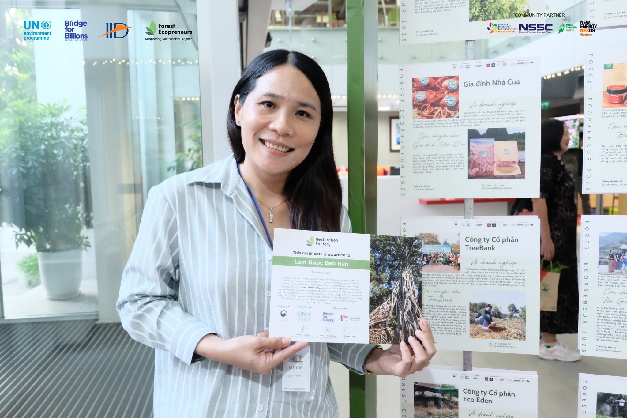 Ms. Lam Ngoc Bao Han, founder of the Crab Family, holding a brochure at an IID exhibition.